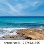 Picturesque Ionian sea beach Punta della Suina, Salento, Puglia, Italy. Gallipoli town view in far.