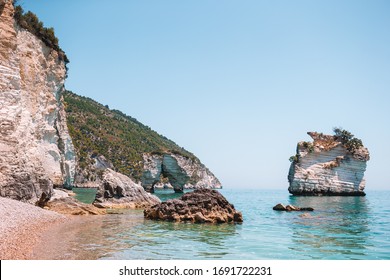 Picturesque islets Faraglioni di Puglia in bay Baia Delle Zagare. Mattinata Faraglioni stacks and beach coast of Mergoli, Vieste Gargano, Apulia, Italy.