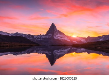 Picturesque landscape with colorful sunrise on Stellisee lake. Snowy Matterhorn Cervino peak with reflection in clear water. Zermatt, Swiss Alps - Powered by Shutterstock