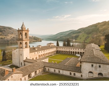 A picturesque landscape dominated by a historical stone structure, possibly a monastery or abbey, with a bell tower - Powered by Shutterstock