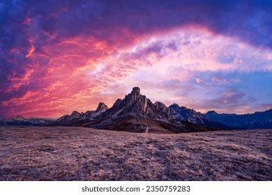 Picturesque landscape during incredible pink sunset in Italian Dolomites mountains. Passo Giau (Giau pass) with famous Ra Gusela and Nuvolau peaks on background. Dolomite Alps, Italy