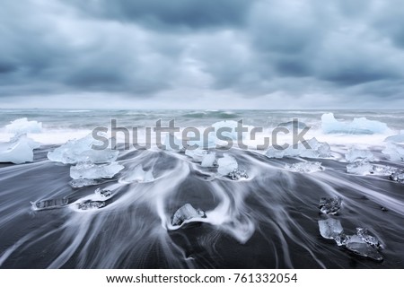 Picturesque landscape with iceberg pieces on Diamond beach near Jokulsarlon lagoon, Iceland. Atlantic Ocean view