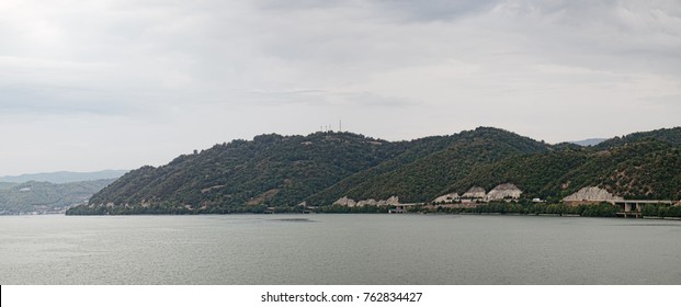 A Picturesque Landscape With A River Bank Covered With Forest And Road Along The Shore. Panoramic View Of The Point Where The Cerna River Meets The Danube, Southwestern Romania's Mehedinti County.