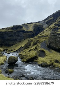 picturesque landscape - a river flows past stone rocks covered with green moss and grass. stones covered with moss lie in the middle of the stream