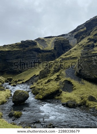 picturesque landscape - a river flows past stone rocks covered with green moss and grass. stones covered with moss lie in the middle of the stream