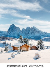Picturesque landscape with small wooden log cabin on meadow Alpe di Siusi on sunrise time. Seiser Alm, Dolomites, Italy. Snowy hills with orange larch and Sassolungo and Langkofel mountains group - Shutterstock ID 2219422975