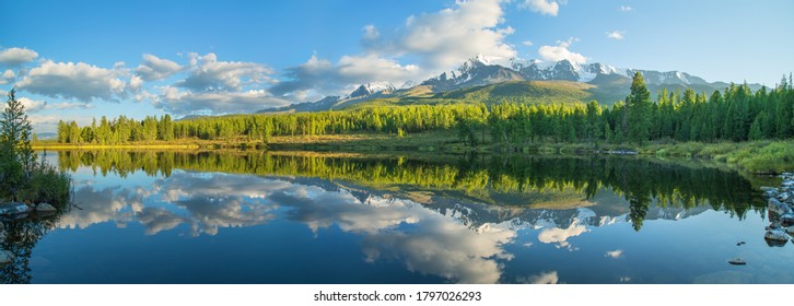 Picturesque mountain lake in the summer morning, Altai. Beautiful reflection of mountains, sky and white clouds. - Powered by Shutterstock