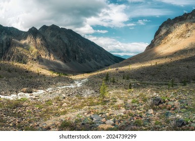 Picturesque mountain valley. Colorful sunny green landscape with river and silhouettes of big rocky mountains and epic deep gorge. Altai Mountains. - Shutterstock ID 2024739299