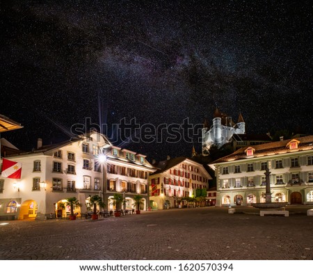 Picturesque nightscape of illuminated buildings and castle of Thun, Switzerland under starry sky. Thun city is a popular travel destination and tourist attraction in Switzerland