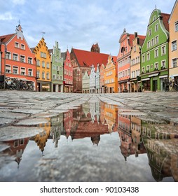 Picturesque old gothic houses reflecting in a puddle in a german city near Munich