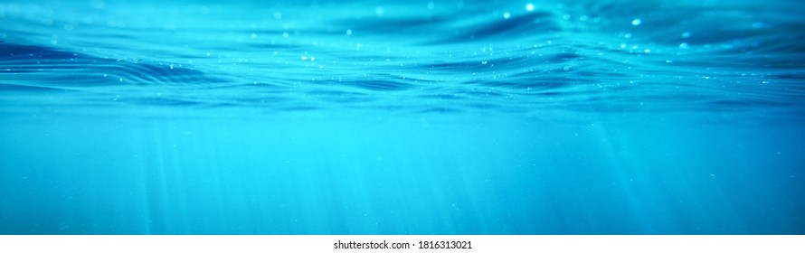 Picturesque panoramic underwater view. Sunbeams in turquoise water. Abstract natural texture, pattern, background, wallpaper, graphic resource. Sea, river, lake, pure nature, environment