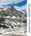 Picturesque panoramic view of the snowy Alps mountains and meadows while hiking Tour du Mont Blanc. Popular hiking route. Alps, Chamonix-Mont-Blanc region, France, Europe.
