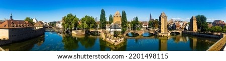 Picturesque panoramic view of Strasbourg cityscape overlooking Ponts Couverts with four towers seen from viewing terrace of Barrage Vauban on sunny summer day, France