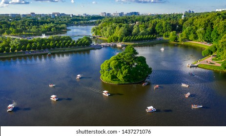 Picturesque Recreation Park In Moscow. Tsaritsyno Palace. Green Tree. River And Floating Boats On It. Lots Of People Walking. Old Building. Filmed With A Drone. Blue Sky With Clouds.