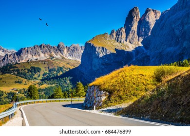 Picturesque road among the rocks on the Sella Pass. Windy sunny autumn day. Travel to South Tyrol, Dolomites. The concept of extreme and ecological tourism