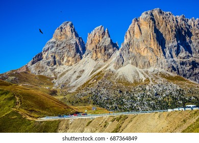 Picturesque road through the pass. Three dizzy dolomite peaks on the Sella Pass, Dolomites. The concept of extreme and ecological tourism
