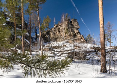 Picturesque rocks against the blue sky in the snow covered winter pine forest, Siberian taiga, the Baikal region, Irkutsk region, Russia - Shutterstock ID 1363043843