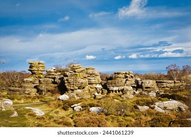 Picturesque rocky landscape with unique rock formations under a blue sky with fluffy clouds at Brimham Rocks, in North Yorkshire