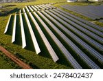 Picturesque scene of solar panels neatly aligned in grassy field, blending harmoniously with the natural landscape and agricultural surroundings