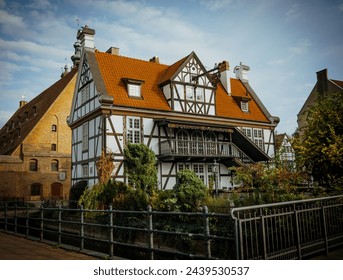 Picturesque scenery of half-timbered building on the river island in European city. Location place: Great Mill (Dwor Mlynarzy), Old Town, Gdansk, Poland.