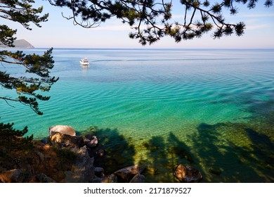 Picturesque seascape. Yacht in a bay with turquoise water color. Coniferous forest. Untouched nature, rest in a wild place
