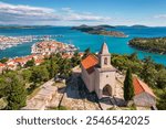 Picturesque St. Nicholas church and the old town of Tribunj on a small island in Adriatic sea, Dalmatia region of Croatia. Beautiful aerial view of the medieval Croatian Tribunj town