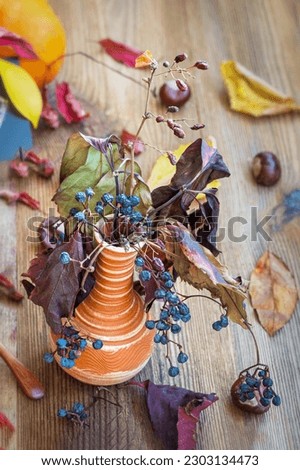 Picturesque still life, dry tree branches in vase. Autumn bouquet. Concept of leaf fall