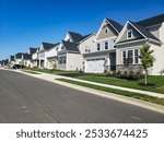 Picturesque street view with modern homes under blue skies. A row of modern detached homes.