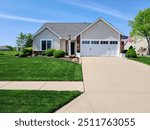 Picturesque Suburban Home with American Flag and Landscaped Yard Front View