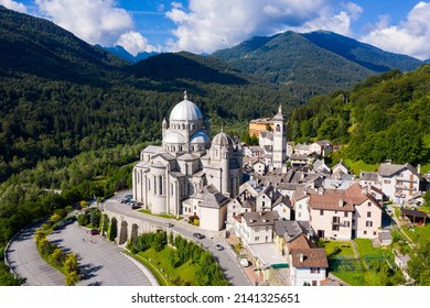 Picturesque Summer View From Drone Of Alpine Township Of Re With Pilgrimage Church Of Virgin Mary Surrounded By Green Alps, Piedmont, Italy