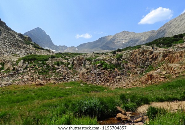 a picturesque  valley , creek,\
and mount toll on a sunny day on the hike to blue lake in summer in\
the indian peaks wilderness area, near nederland,\
colorado