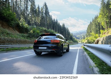 Picturesque view of asphalt road with modern black car