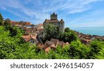 The picturesque view of the beautiful medieval castle Meersburg and the roofs of the old town on a sunny summer day. The castle Meersburg on the background of the blue sky, lake Constance and Alps.