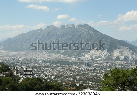 Picturesque view of city near high mountain under blue sky