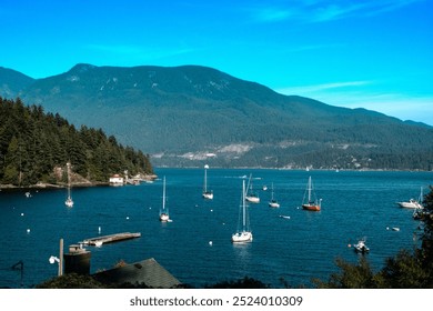 A picturesque view of a large lake surrounded by a majestic mountain range and dense forests - Powered by Shutterstock