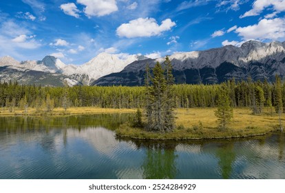 A picturesque view of majestic mountains and lush forest mirrored in a tranquil lake under a bright blue sky in British Columbia, Canada. - Powered by Shutterstock