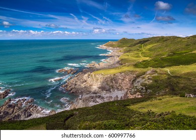 Picturesque view of the North coast of Devon. Grunta beach and Mortehoe point in the distance. Striped sky. England