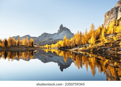 Picturesque view on Federa Lake in sunrise time. Autumn mountains landscape with Lago di Federa and bright orange larches in the Dolomite Apls, Cortina D'Ampezzo, South Tyrol, Dolomites, Italy