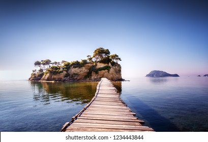 Picturesque view on lonely island Cameo in Greece, part of island Zakynthos or Zante, Port Sostis. Dramatic scenery of solitude island in ocean with wooden path. Iconic landmark on Zakinthos island. - Shutterstock ID 1234443844