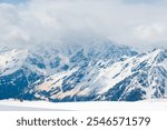 A picturesque view of the rocky white peaks of the mountains of the North Caucasus range from the snow-covered slope of Mount Elbrus. Caucasus