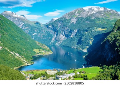 A picturesque view of a serene Norwegian fjord nestled between towering mountains, the calm blue water reflecting the surrounding lush greenery. Geiranger Fjord Norway - Powered by Shutterstock