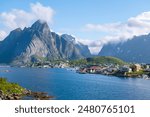 A picturesque village nestled amidst towering mountains and a calm fjord in Norway. Reine, Lofoten, Norway