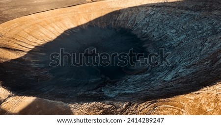 A picturesque volcano crater on the Montana Blanca mountain at sunset against the backdrop of a volcanic landscape with desert, lava formations. Traveling on the island of Lanzarote, Canary Islands.