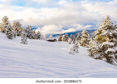 A picturesque winter landscape with a small house, trees and mountains in Stryn, Norway