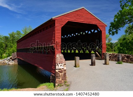 the picturesque, wooden, red  sachs covered bridge over marsh creek on a sunny summer day, near gettysburg, pennsylvania
