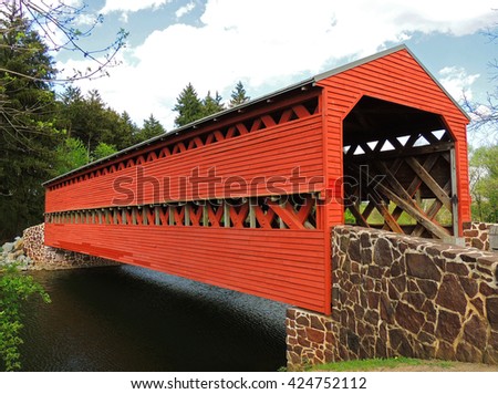    Picturesque wooden, red sachs covered bridge over marsh creek in spring in  gettysburg, pennsylvania       