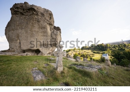 Pidkamin inselberg stone on hill and ancient graveyard. Ukraine.