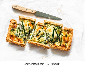 Pie with asparagus, mozzarella and spinach on a light background, top view. Delicious snack, tapas, appetizer   
