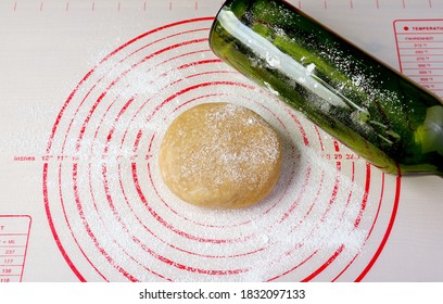 Pie Dough With Wine Bottle Used As A Rolling Pin On A Baking Mat For The Concept Of Baking At Home