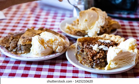 Pie A La Mode State Fair Pies With Ice Cream Apple, Pecan, Rhubarb Pies On A Checkered Table Cloth With Fork And Hand